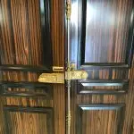 Antique and unique mechanism with decorative handles on special double wooden door entrance to luxury apartment