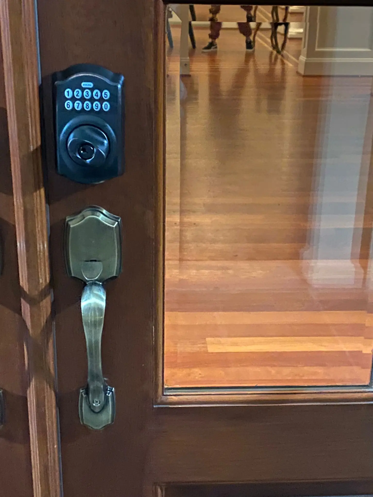keypad lock with bulging buttons with key entry in black and separate decorative handle on glass door