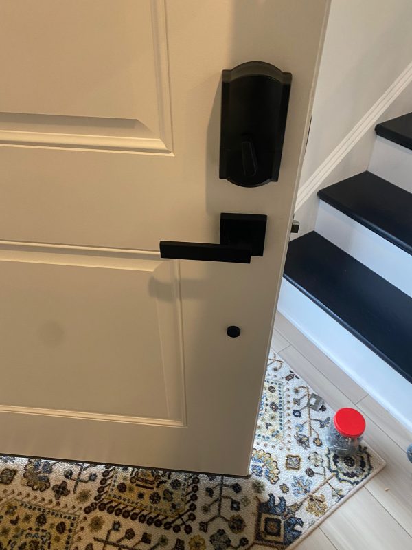 black digital combination lock view from inside deadbolt and separate lever handle on residential white door